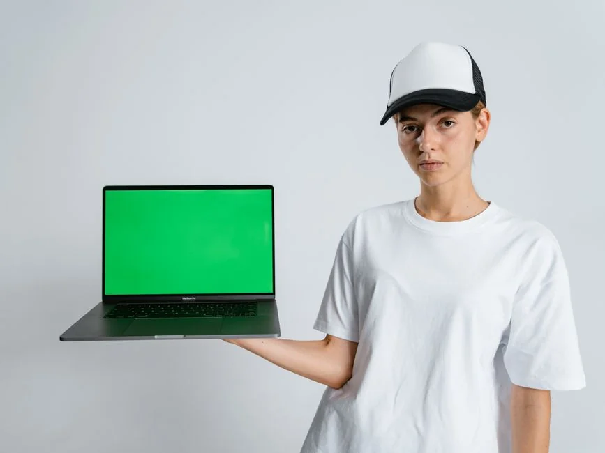 A smartphone in a miniature cart on a laptop symbolizes online shopping and digital payment.